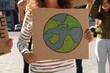 © New Africa - African American woman with poster protesting against climate change outdoors, closeup