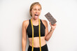 pretty caucasian woman with cheerful and rebellious attitude, joking and sticking tongue out. chocolate and fitness concept