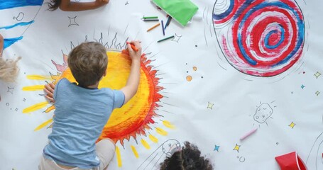 young children and friends paint colorful space pictures indoors on the floor in kindergarten from t