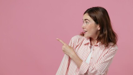 Wall Mural - Young shocked surprised amazed excited woman 20s she wearing shirt t-shirt look aside on workspace area mock up isolated on plain pastel light pink background studio portrait. People lifestyle concept