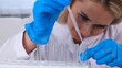 © Евгения Медведева - professional scientist laboratory assistant takes and examines samples using a micropipette and test tubes to work under a microscope in a laboratory, close up.