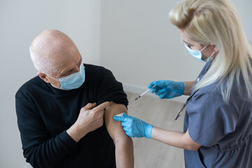 Poster - Doctor making injection to senior patient in clinic