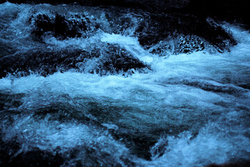 icy blue water and black rocks