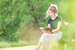 © Lydia - Young woman reading Bible on bench