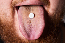 Man Taking Pill, Mouth Open With Tongue Sticking Out.