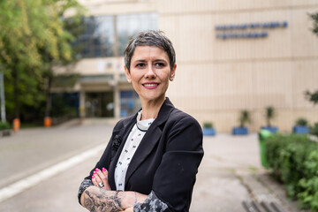 One woman mature or senior caucasian female standing in front of the building university professor or company manager in day waist up portrait front view copy space real people smile