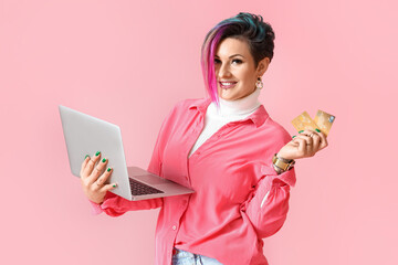 Poster - Beautiful woman with credit cards and laptop on pink background