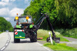 Maintenance of the edge of a road by a brush cutter tractor. Tractor with a mechanical mower mowing grass