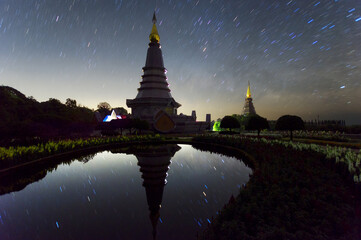 Wall Mural - star trails moving over a sacred temple at doi inthanon national park, chiang mai, thailand.