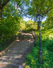 A Stairway Carved Into The Riverside Park With Lamp Posts