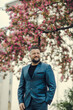 © sharshonm - Portrait of a successful  young guy.Portrait of handsome successful smiling man near flowering tree in park.