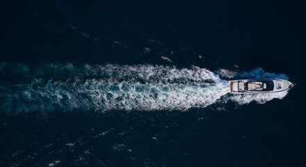 Wall Mural - big mega yacht fast movement on dark water in the sea top view. Large super yacht In motion on dark water aerial view.