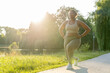 © gpointstudio - Plus sized African American woman exercising at the park in a  summer day