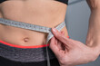 Slim woman measuring her thin waist. Slim figure after weight lose
