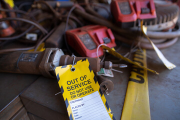 Safety workplaces yellow out of service tag attached on faulty damage  metal die grinder power tools  construction site Perth, Australia