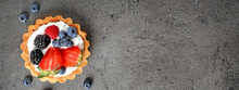 Tasty Tartlet With Fresh Berries On Grey Table, Top View With Space For Text. Banner Design