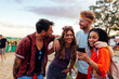 © bernardbodo - Group of friends going to music festival and using phone