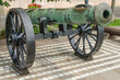 An old cannon on a gun carriage exposed on the street