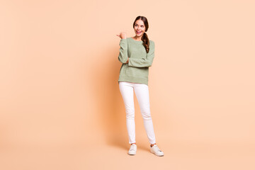 Sticker - Full length photo of dreamy pretty lady wear green sweater pointing thumb empty space isolated beige color background