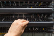 © fivan - Closeup view of engineer openenning data voice patch panel for switching cables. Communication and networking concept