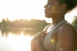 © gpointstudio - African American woman practicing breathing exercise at the park