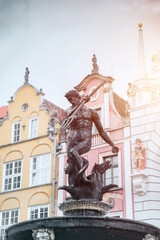 Neptune Fountain in front of a colorful building in Gdansk Poland. Concept of travel destination in eastern Europe.