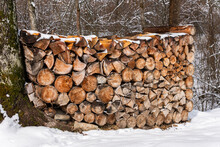A Lot Of Chopped Wood Outdoors, Covered With Snow In Winter