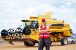 © ADDICTIVE STOCK - Content woman standing near combine harvester