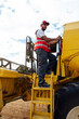 © ADDICTIVE STOCK - Man standing on ladder of combine harvester