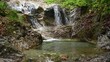 Schöne Wasserfälle fließen in ein Becken mit sehr klarem Wasser. Das Wasser des Bergbachs ist sehr sauber und trinkbar. Im Sommer kann man hier baden gehen.