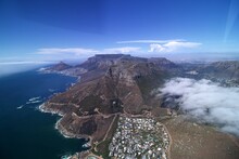 Wide Angle Aerial View Of Coast Line From Hout Bay To Cape Town With Rocks Twelve Apostles, Table Mountain And Lions Head, Blue Sea, Blue Sky Few White Clouds