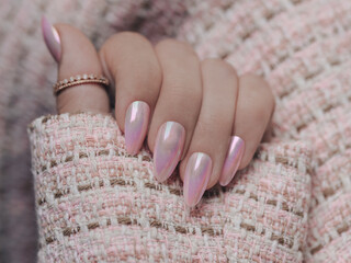 Wall Mural - Beautiful pink nail manicure. Stylish pastel pink manicure. Nail polish. Art pink manicure. Female hands manicure close up view on pink knitted blzer background.