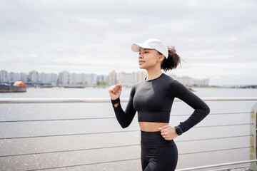 Wall Mural - A woman runs, does fitness, uses a tracker on her arm, a smart watch for sports, trains in sportswear