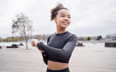 Wall Mural - A sporty woman uses a tracker on her hand smart watch for sports