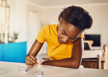 Testing for virus, disease and illness during covid pandemic at home. One serious, anxious and black female using a self medical test kit to check for sickness on a table or counter alone at home