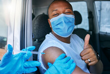 Drive Thru Covid And Corona Virus Vaccine Site As A Public Service For The People. Man Giving Thumbs Up And Endorsing The Jab While Wearing A Mask To Avoid Infection, Approving Being Vaccinated