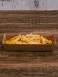 Truffle fries with shaved truffle flakes in cardboard tray