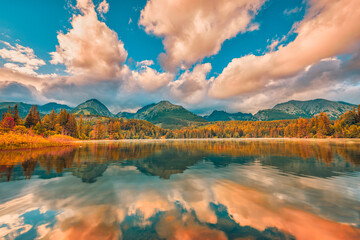 Wall Mural - Beautiful autumn landscape. Idyllic travel background, beauty in nature concept. Tatra mountains orange yellow forest trees, sunset lake view. Amazing sky clouds and fall water reflection panorama