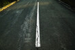 Worn white road line on cracked asphalt close-up