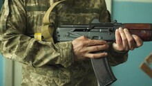 a soldier in camouflage uniform takes aim with his machine gun, preparing to fire close-up. fighting inside the building. firing at the enemy army. Kalashnikov shooting. combat clashes