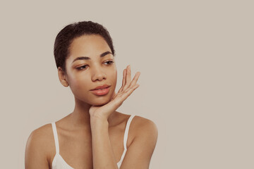 Wall Mural - Cheerful young woman smiling happily while looking aside.