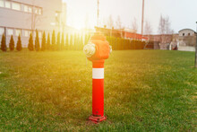 Single Red Fire Hydrant On Green Sunrise Lawn,near Factory.Autumn,spring,summer Day.