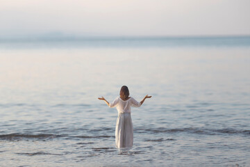 woman makes yoga exercises in front of ocean