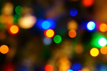 Wall Mural - Abstract blurred background. Christmas tree toys and glowing garlands on the Christmas tree.