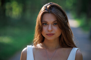 Wall Mural - Girl walks in the forest. Big eyes. Сlose-up portrait of a young brunette girl.