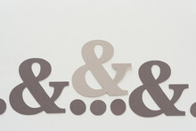 Three Paper Ampersands And A Set Of Dots (indicating An Ellipsis)