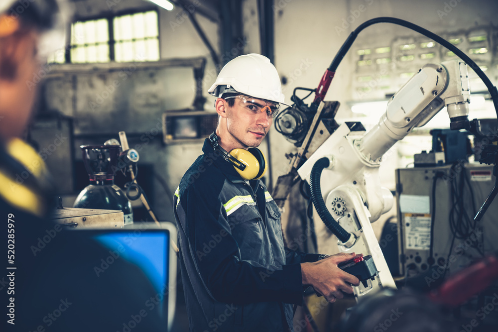 Factory workers working with adept robotic arm in a workshop . Industry ...