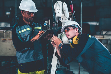 Wall Mural - Factory workers working with adept robotic arm in a workshop . Industry robot programming software for automated manufacturing technology .