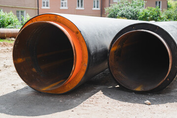 Plumbing repair outdoors concept. Two new industrial pipes lying on ground, close-up