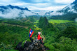 © tawatchai1990 - Tourist holding Lao flag on the Nam Xay Viewpoint, During the rainy season in Vang Vieng, Laos.